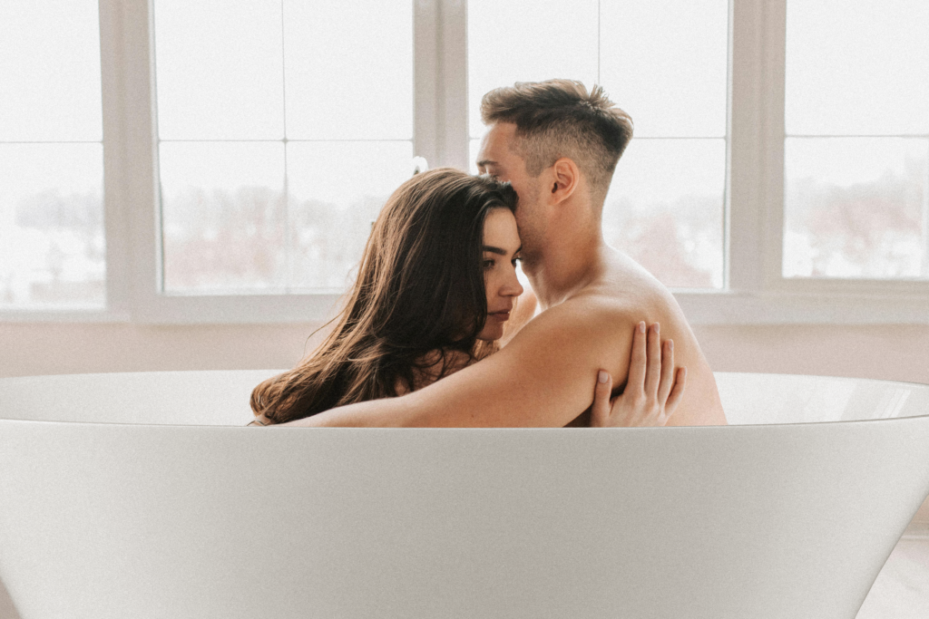 homem e mulher brancos abraçados dentro de uma banheira de imersão. 