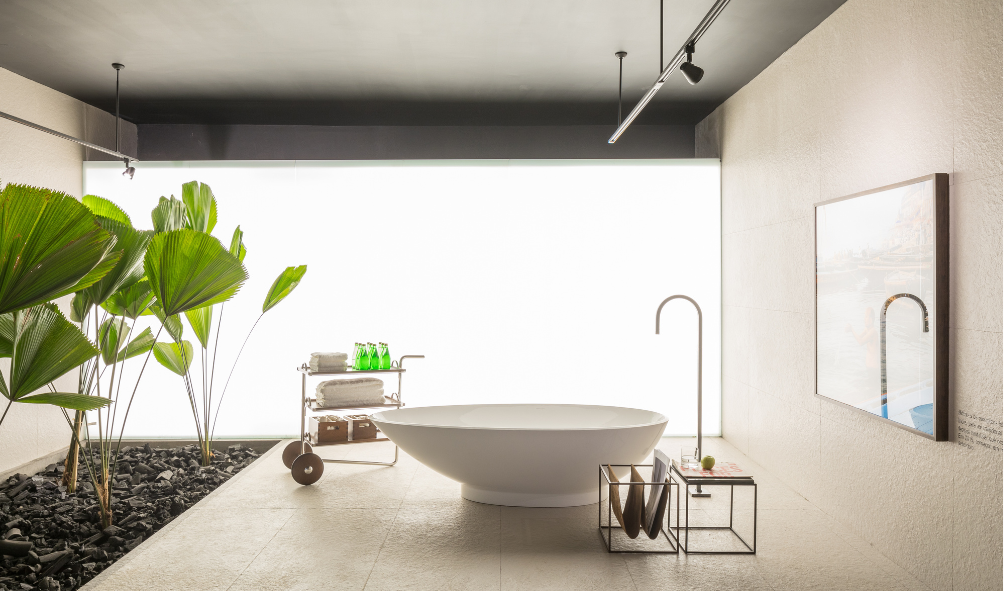 Banheira em uma sala de banho ampla com plantas