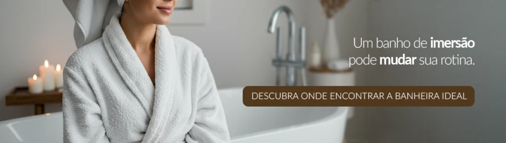 Mulher de roupão branco sentada em frente a banheira com velas acesas, destacando o banho de imersão como experiência relaxante. Um banho de imersão pode mudar sua rotina. CTA: DESCUBRA ONDE ENCONTRAR A BANHEIRA IDEAL