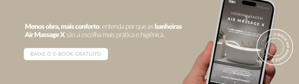 Banner promocional em fundo bege com a frase “Menos obra, mais conforto: entenda por que as banheiras Air Massage X são a escolha mais prática e higiênica”. À esquerda, botão branco escrito “BAIXE O E-BOOK GRATUITO”. À direita, mão segurando celular que exibe a capa do e-book “Hidromassagem Air Massage X” com a imagem de uma banheira moderna.