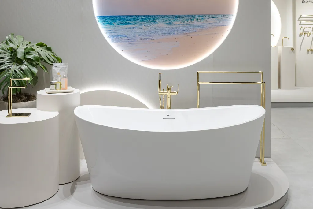 Banheira de imersão em branco fosco com design sofisticado e metais dourados, exposta em ambiente minimalista com inspiração natural — tendência de bem-estar e spa em casa para 2026.